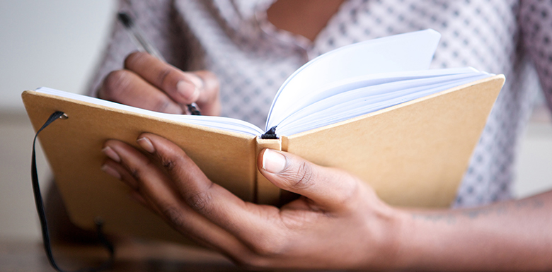 Woman writing in plain journal image