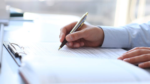 Man filling out forms on a clipboard