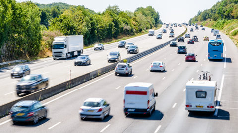 Cars driving down highway in afternoon