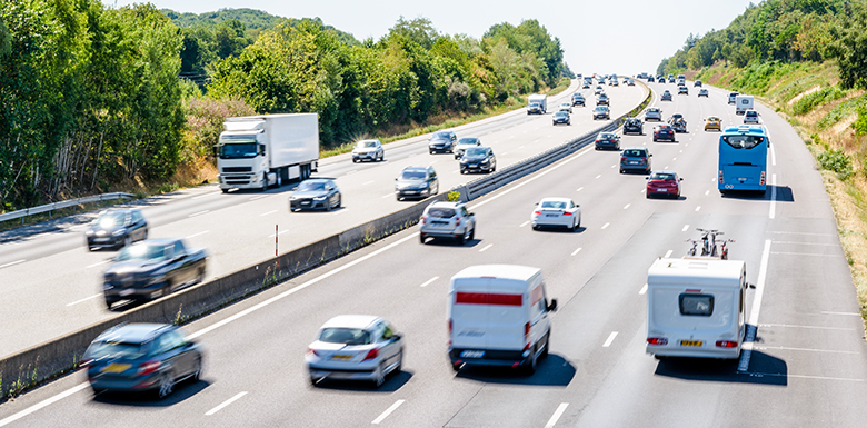 Cars driving down highway in afternoon