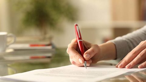 Woman filling out paperwork with pen