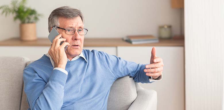 Older man on the phone with serious expression