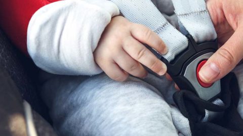 Woman putting child in car seat