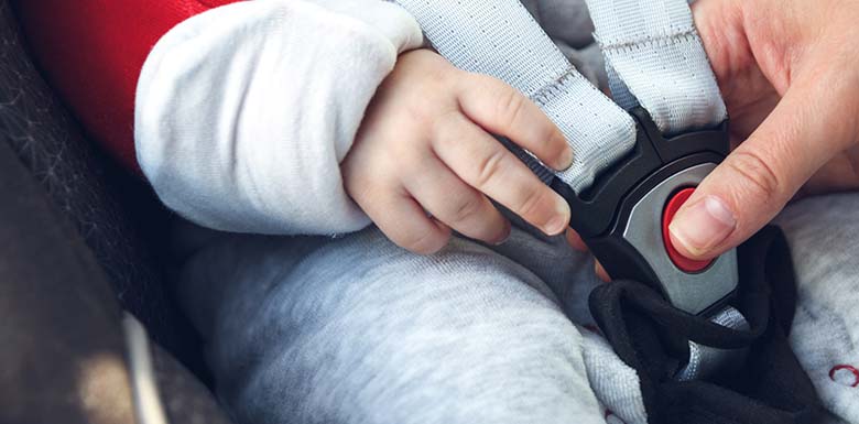 Woman putting child in car seat