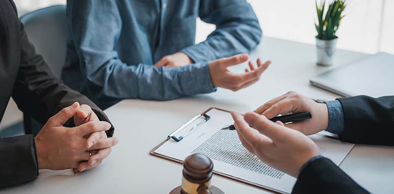 Two men talking to lawyer