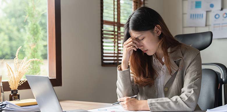 Woman with head in hands at work